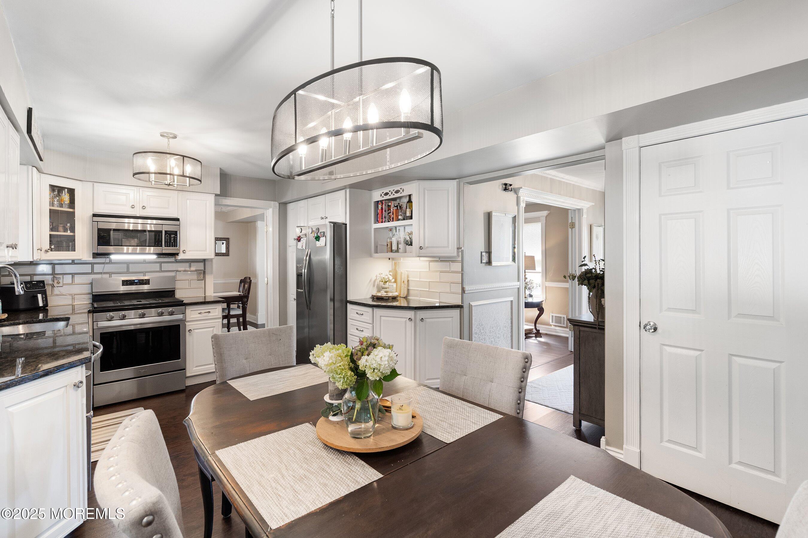 20 Appletree Road Howell, NJ 07731 - Photo 6 of 35 a kitchen with stainless steel appliances granite countertop a refrigerator a stove a microwave oven a dining table and chairs with wooden floor