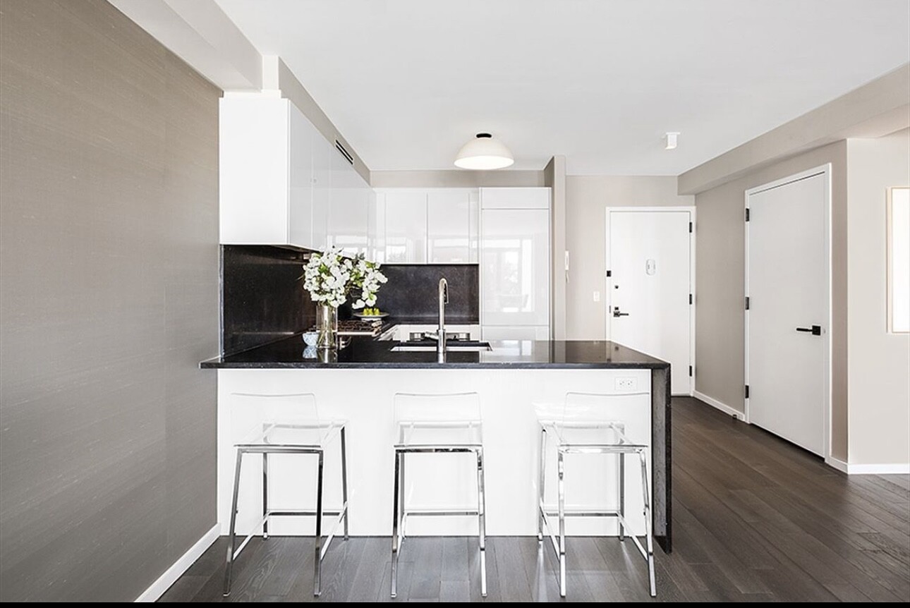 385 1st Avenue, Unit 12D Manhattan, NY 10010 - Photo 2 of 19 a kitchen with white cabinets and chairs