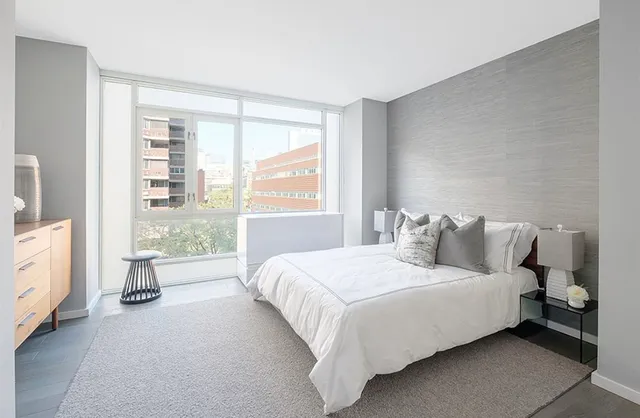 a bedroom with a bed and a large window