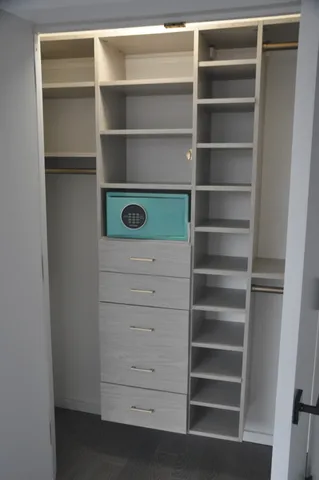 a view of walk in closet with empty racks
