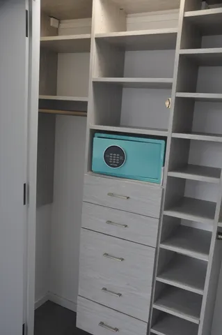 a view of walk in closet with empty racks