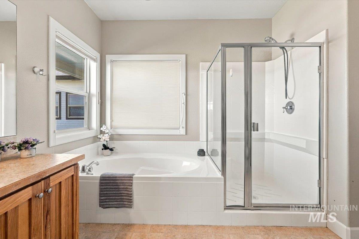 18026 Briar Creek Road Murphy, ID 83650 - Photo 24 of 50 Wood-finish vanity with an integrated sink, broad mirror, and warm-toned countertop