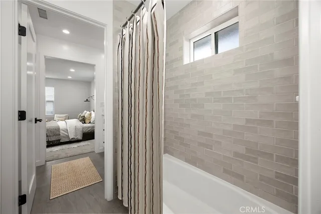 a en suite bathroom with a tub shower and bedroom view