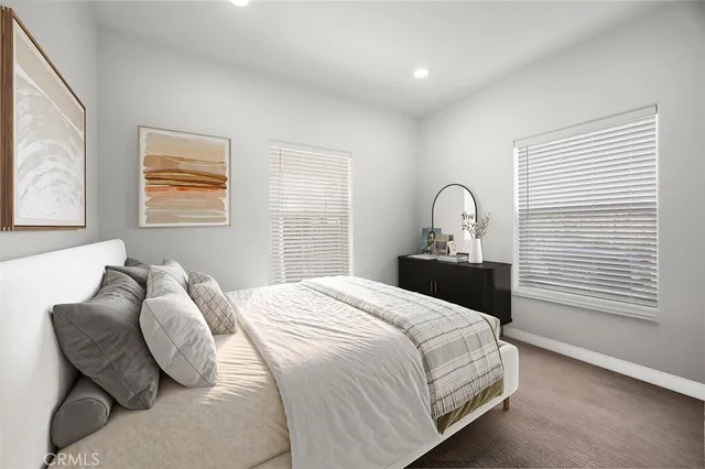 a bedroom with a bed and dresser with mirror