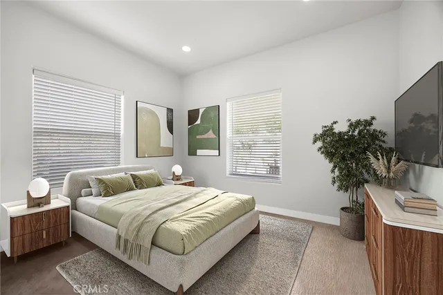 a bedroom with a large bed and a potted plant