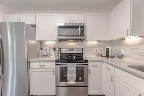 a kitchen with cabinets stainless steel appliances and a sink