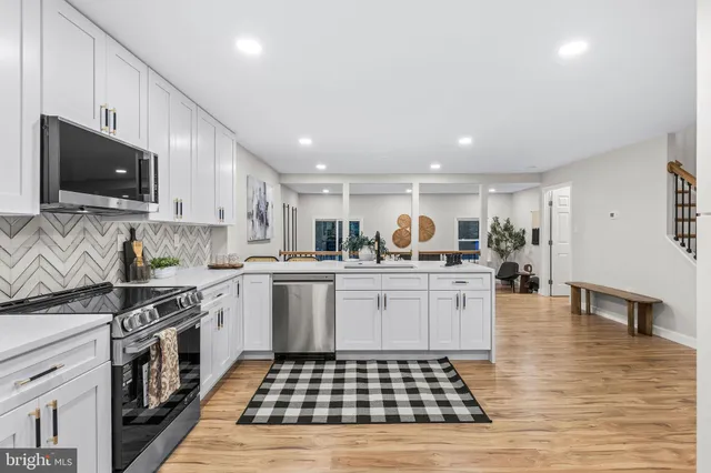 a kitchen with stainless steel appliances granite countertop a stove a sink a refrigerator and a microwave