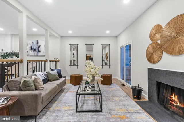 a living room with fireplace furniture and a large window