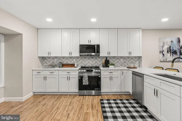 a view of a livingroom with wooden floor and a kitchen