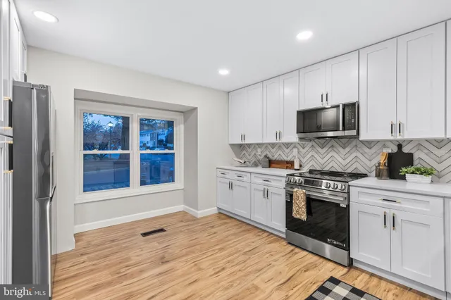 a kitchen with granite countertop white cabinets and white appliances