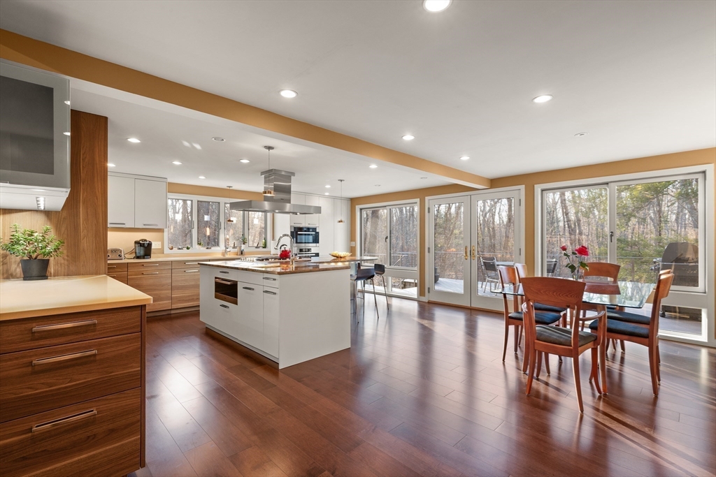 a open kitchen with stainless steel appliances granite countertop a stove dining table and chairs