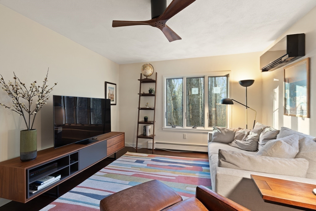 175 Mountain Street Sharon, MA 02067 - Photo 10 of 28 a living room with furniture a flat screen tv and a floor to ceiling window