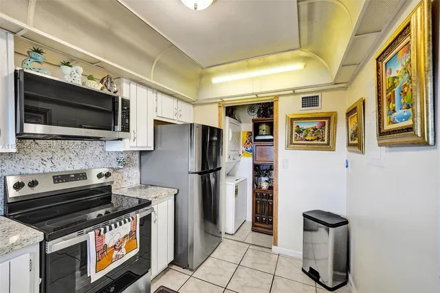 a kitchen with stainless steel appliances granite countertop a sink and a refrigerator