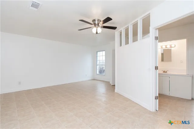 a view of a livingroom with a ceiling fan and window