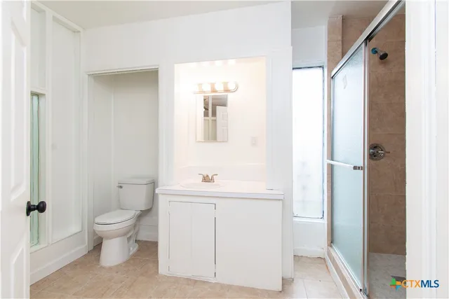 a bathroom with a toilet a sink and a mirror