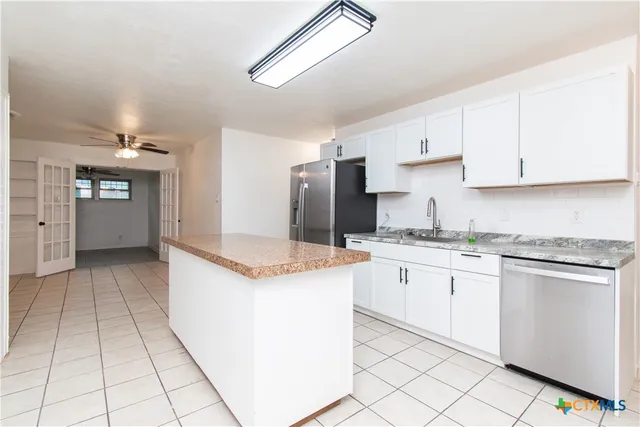 a kitchen with granite countertop cabinets and refrigerator