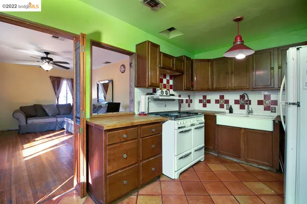 a kitchen with kitchen island granite countertop wooden cabinets and white appliances