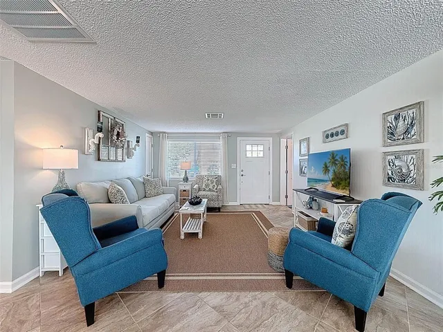 a bedroom with a bed and a large window with a dresser