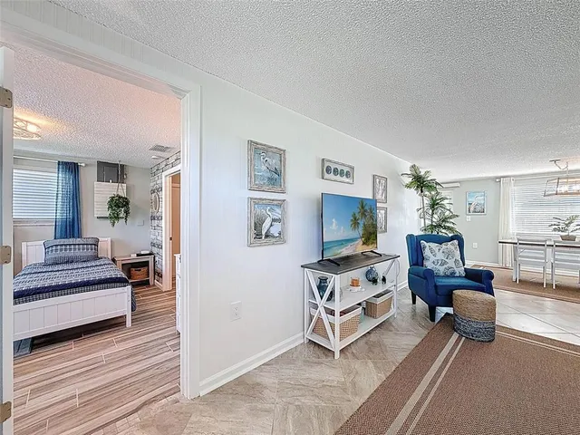 a living room with furniture a flat screen tv and a large window