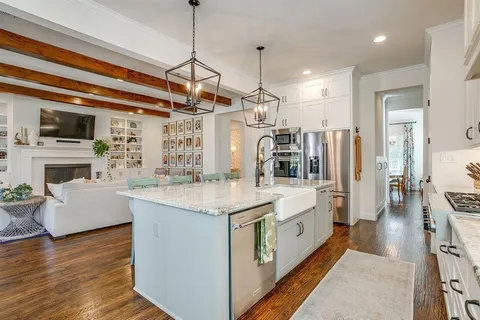a large white kitchen with a stove and a refrigerator
