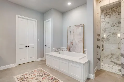 a spacious bathroom with a double vanity sink a mirror and a bathtub