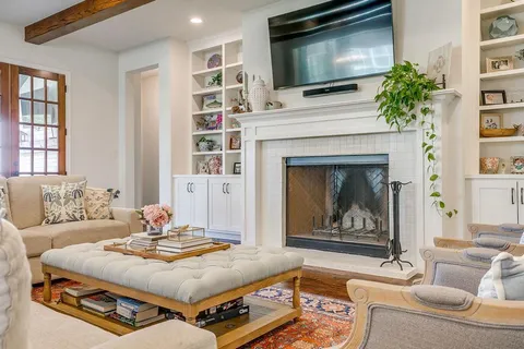 a living room with furniture a flat screen tv and a fireplace