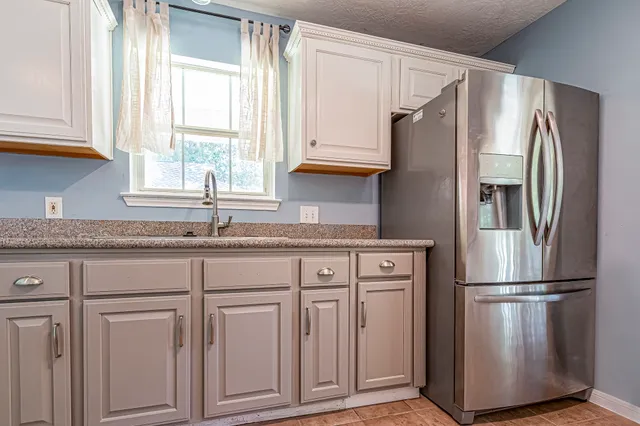 a kitchen with granite countertop a stove microwave and cabinets