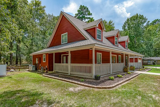 a front view of a house with a yard and trees