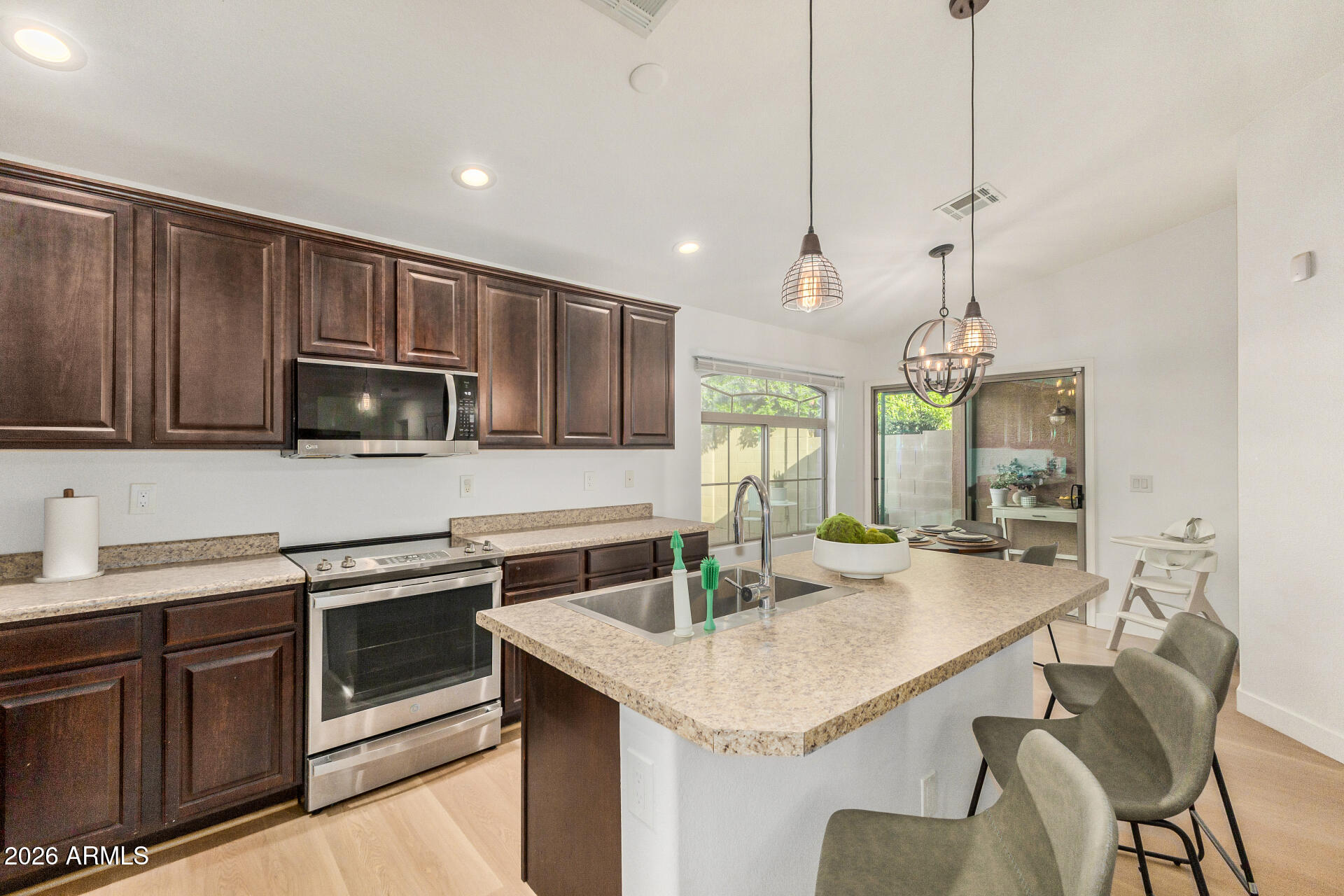2725 East Mine Creek Road, Unit 1101 Phoenix, AZ 85024 - Photo 13 of 43 a kitchen with stainless steel appliances granite countertop a sink a stove a microwave and island