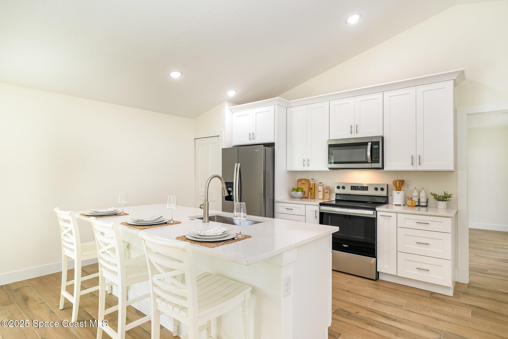 6003 Gilson Avenue Cocoa, FL 32927 - Photo 11 of 27 a kitchen with stainless steel appliances kitchen island granite countertop a sink a stove a microwave a counter top space and cabinets