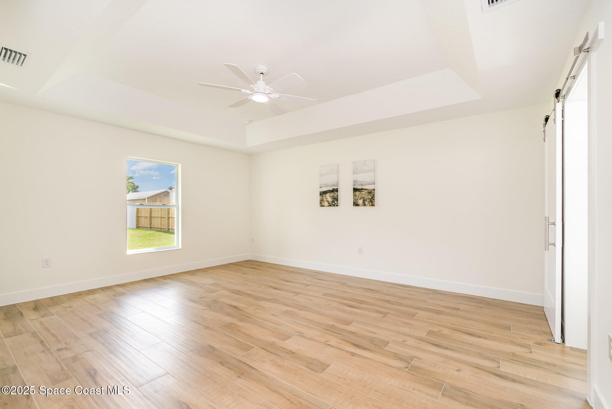 6003 Gilson Avenue Cocoa, FL 32927 - Photo 14 of 27 an empty room with wooden floor fan and windows