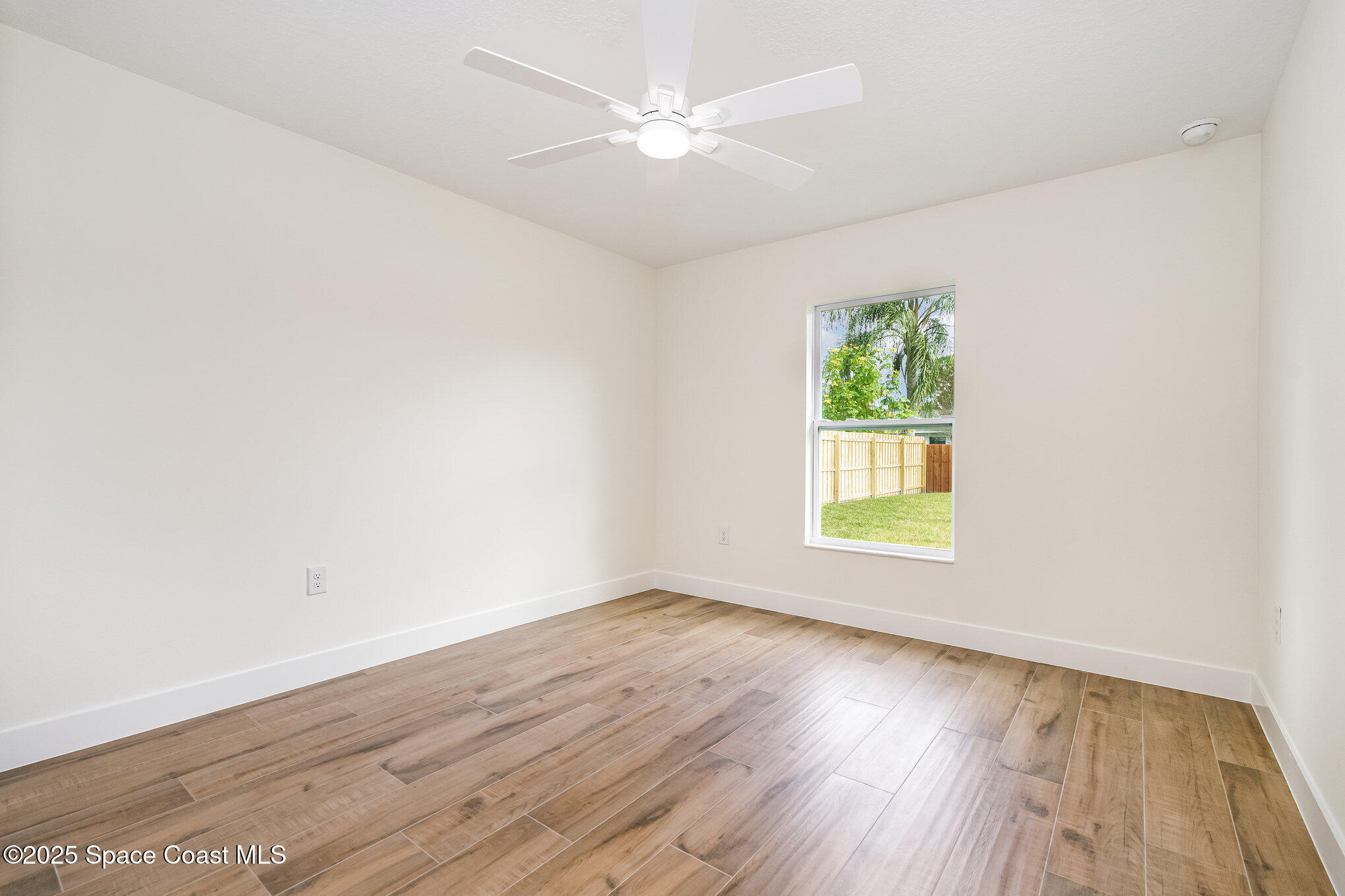 6003 Gilson Avenue Cocoa, FL 32927 - Photo 19 of 27 an empty room with wooden floor and windows
