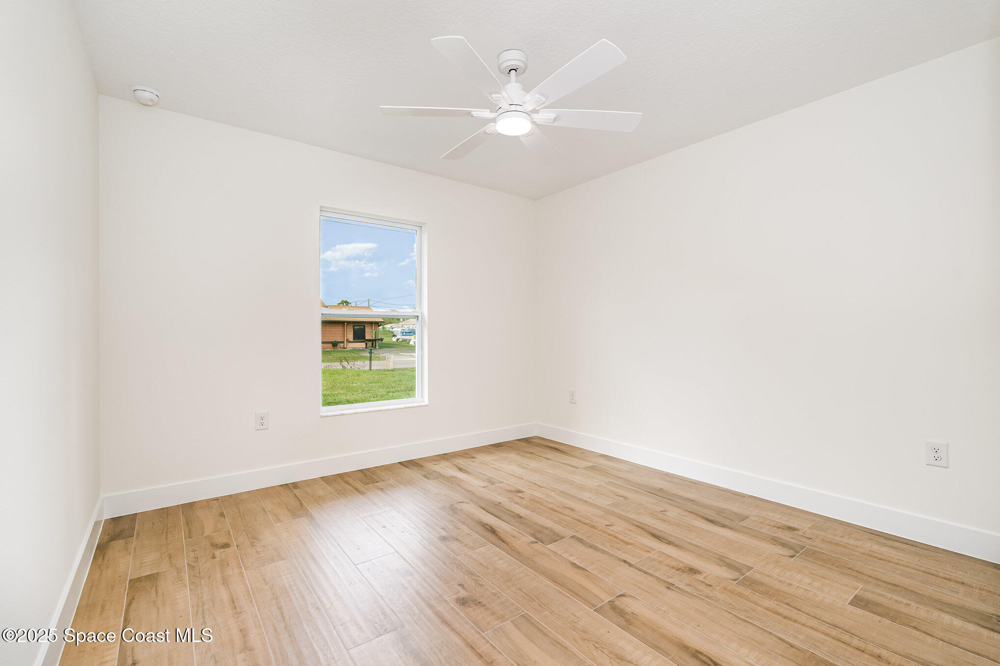 6003 Gilson Avenue Cocoa, FL 32927 - Photo 20 of 27 an empty room with wooden floor and windows
