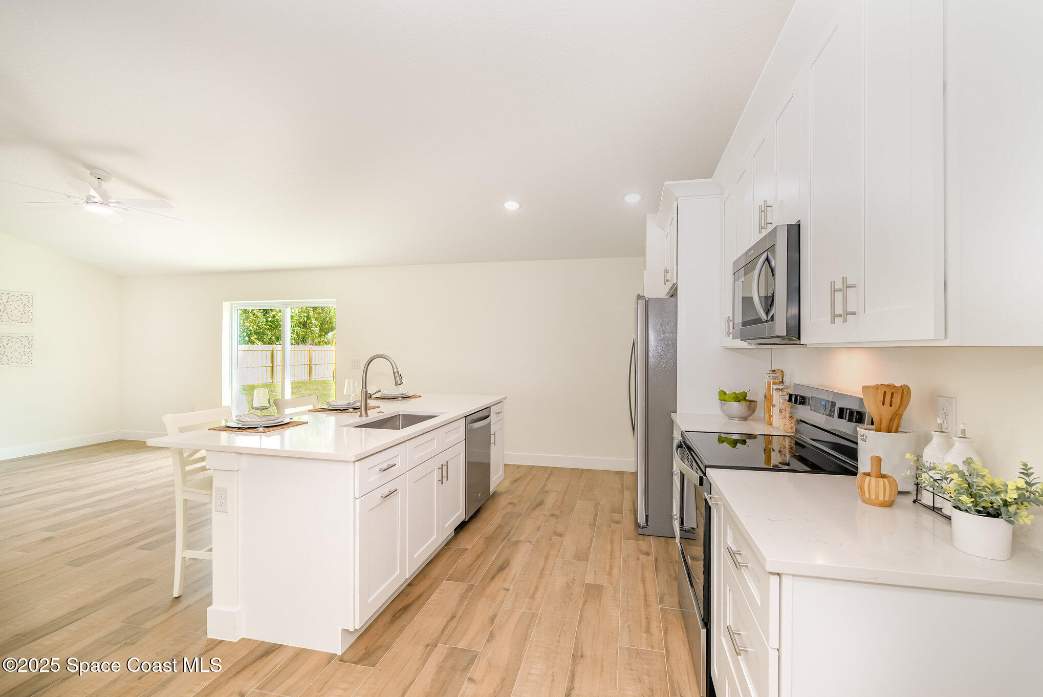 6003 Gilson Avenue Cocoa, FL 32927 - Photo 10 of 27 a kitchen with a sink stove and cabinets