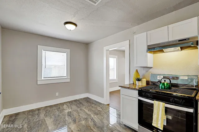a kitchen with stainless steel appliances granite countertop a sink stove and cabinets