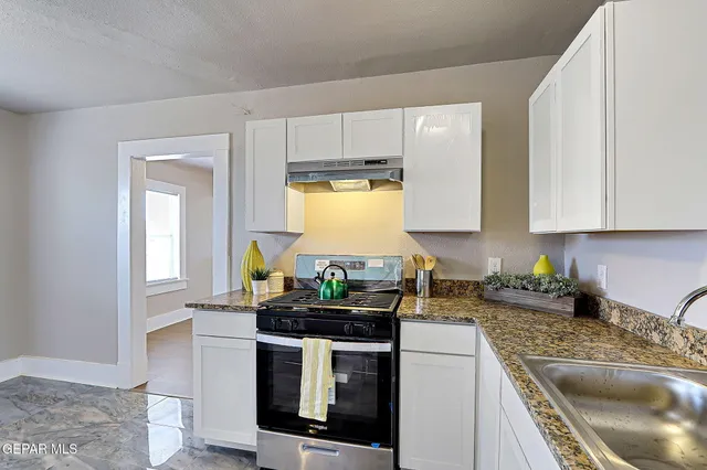 a kitchen with stainless steel appliances granite countertop a sink a stove a cabinets a counter space and cabinets