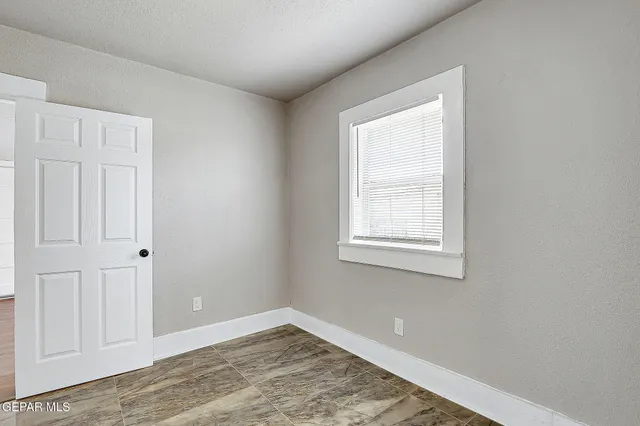 a view of a small space with wooden floor and a window