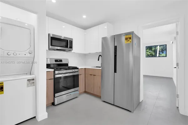 a kitchen with stainless steel appliances a refrigerator stove and microwave