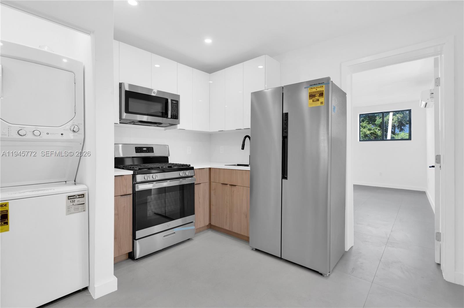 3040 Northwest 93rd Street, Unit A Miami, FL 33147 - Photo 3 of 6 a kitchen with stainless steel appliances a refrigerator stove and microwave