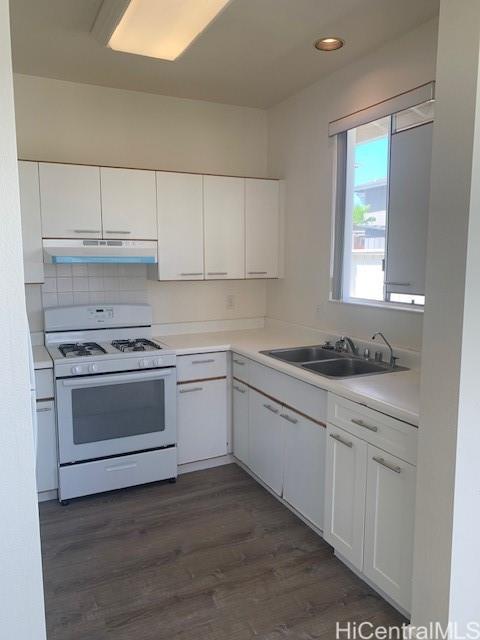 91-211 Kakuhihewa Place, Unit F Kapolei, HI 96707 - Photo 7 of 25 a kitchen with granite countertop white cabinets and white appliances