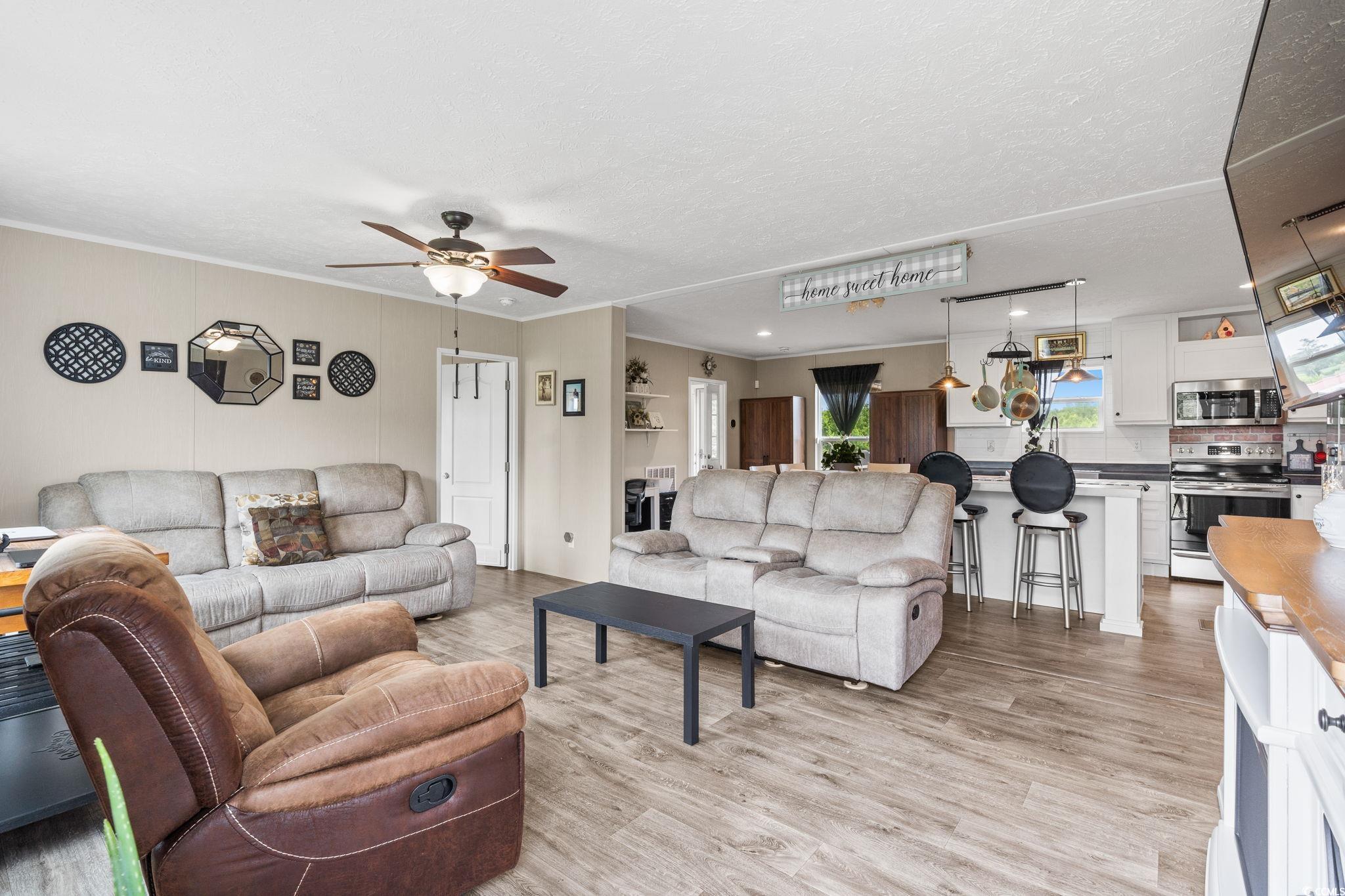 167 Dove Road Loris, SC 29569 - Photo 8 of 40 Living room with ceiling fan, light wood finished