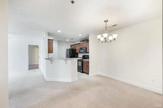 a view of a kitchen with kitchen island and stainless steel appliances