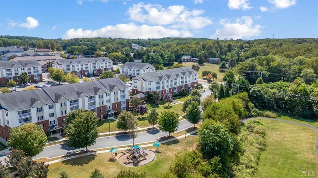 an aerial view of residential houses with outdoor space and trees
