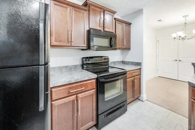 a kitchen with stainless steel appliances granite countertop a stove a microwave and a refrigerator