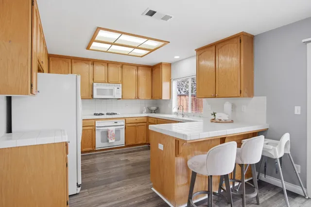 a kitchen with a sink cabinets and wooden floor