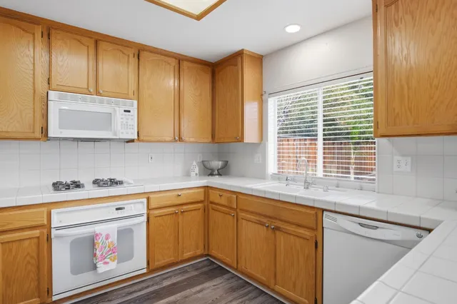 a kitchen with stainless steel appliances wooden cabinets and a sink