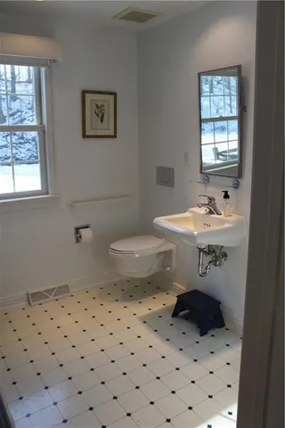 a bathroom with a sink a toilet and window