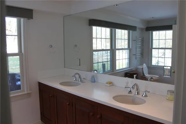a bathroom with double vanity sinks and a mirror