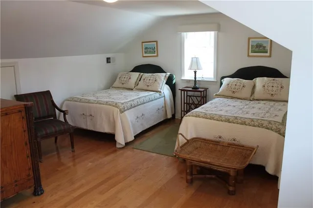 a bedroom with two beds and a chair