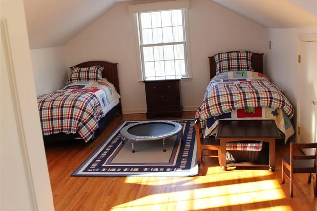 a living room with a bed furniture a rug and a window
